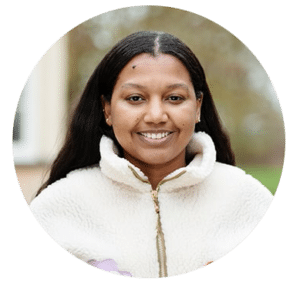 A smiling woman with long hair and a white jumper