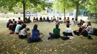 Group of people sat in a circle in the park