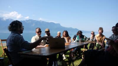 Group of people gathered around a table against beautiful mountain scenery